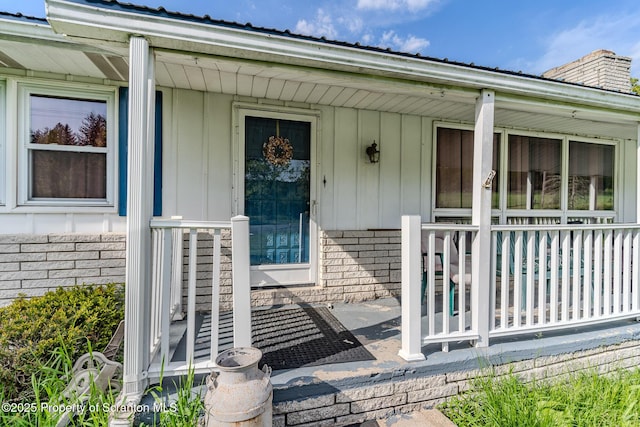 505 Yedinak Ln, Madison Twp, PA 18444 - view of exterior entry featuring a porch, a chimney, brick siding, and metal roof