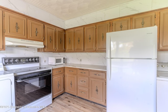505 Yedinak Ln, Madison Twp, PA 18444 - kitchen with white appliances, under cabinet range hood, washer / clothes dryer, light countertops, and light wood-type flooring