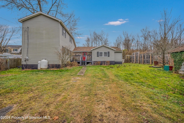 rear view of house featuring a wooden deck and a yard