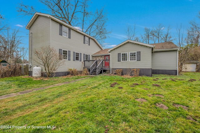 back of house featuring a yard and a wooden deck