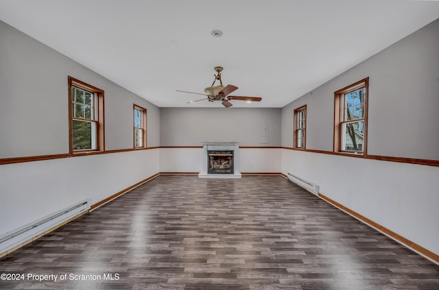 unfurnished living room featuring ceiling fan, dark hardwood / wood-style floors, and a baseboard heating unit