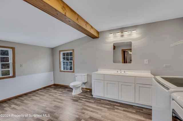 bathroom with hardwood / wood-style floors, vanity, vaulted ceiling with beams, toilet, and separate washer and dryer