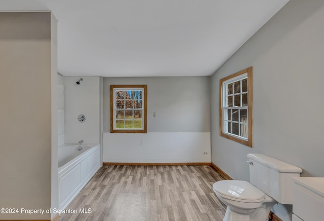 bathroom featuring hardwood / wood-style floors, toilet, lofted ceiling, and tub / shower combination