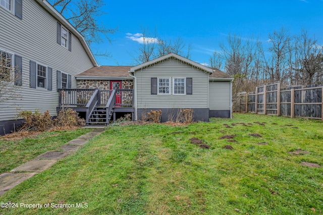 rear view of property with a lawn and a wooden deck