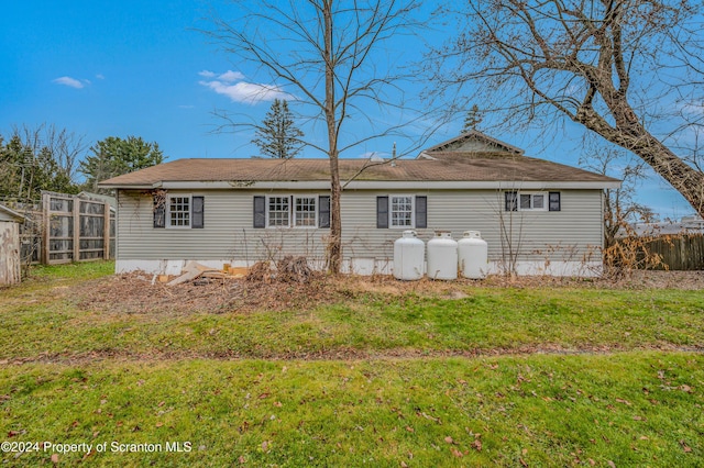 rear view of property featuring a lawn