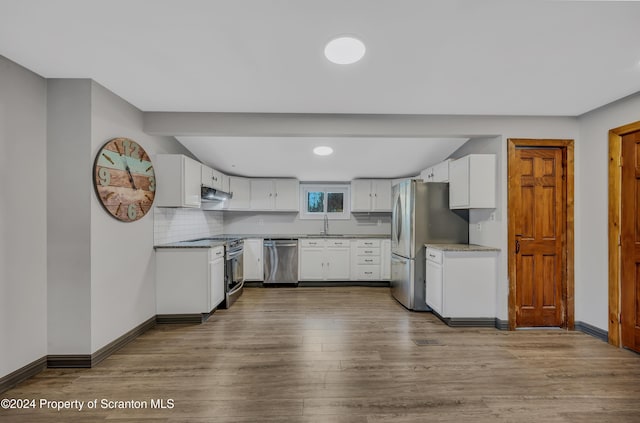 kitchen featuring white cabinetry, sink, stainless steel appliances, and hardwood / wood-style flooring