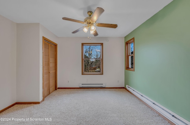 unfurnished bedroom featuring ceiling fan, a closet, light colored carpet, and a baseboard radiator