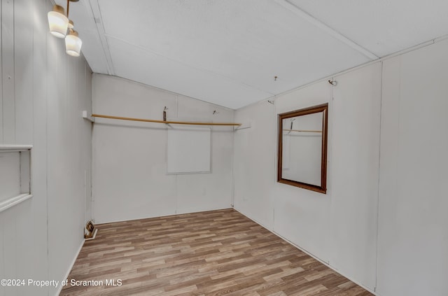 empty room with light hardwood / wood-style floors and lofted ceiling