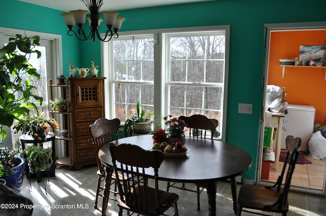 dining space with tile patterned flooring, a wealth of natural light, and a chandelier