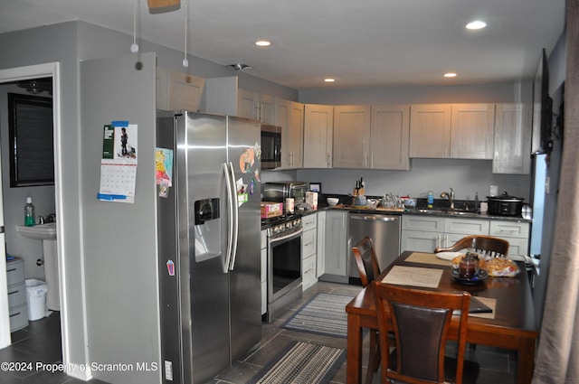 kitchen with dark tile patterned floors, sink, and appliances with stainless steel finishes