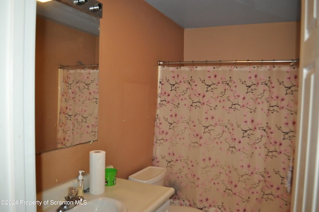 bathroom with walk in shower, vanity, and toilet