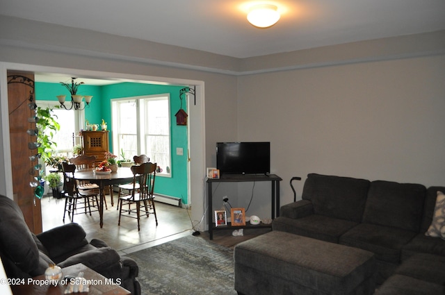 living room featuring a baseboard heating unit, concrete flooring, and an inviting chandelier