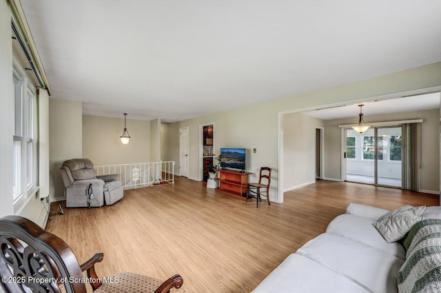 living area with baseboards and wood finished floors