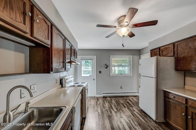 kitchen with white appliances, ceiling fan, a baseboard radiator, under cabinet range hood, and a sink