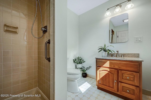 bathroom featuring vanity, baseboards, toilet, and tiled shower
