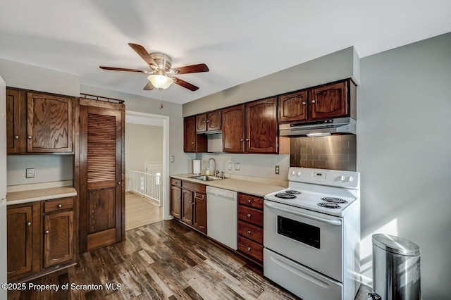 kitchen featuring ceiling fan, a sink, light countertops, under cabinet range hood, and white appliances