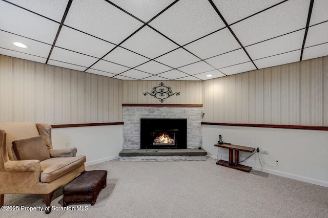 sitting room featuring carpet floors, baseboards, a fireplace, and a paneled ceiling