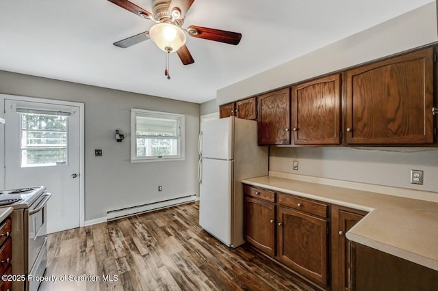 kitchen featuring white appliances, a ceiling fan, baseboard heating, and light countertops