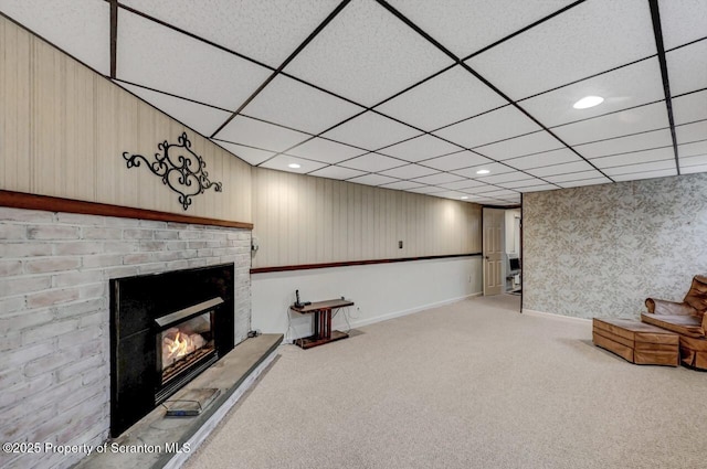 interior space with baseboards, carpet, a brick fireplace, and wallpapered walls