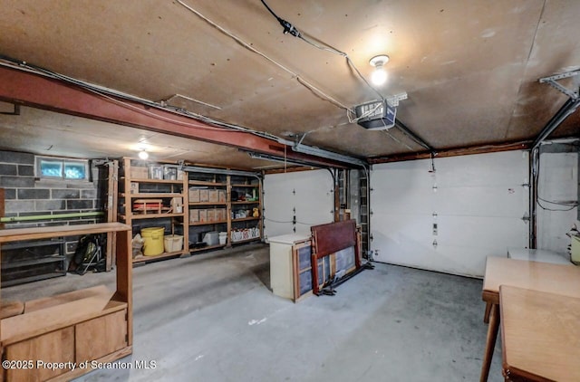 garage featuring a garage door opener and concrete block wall