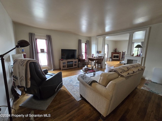 living room with hardwood / wood-style flooring and decorative columns