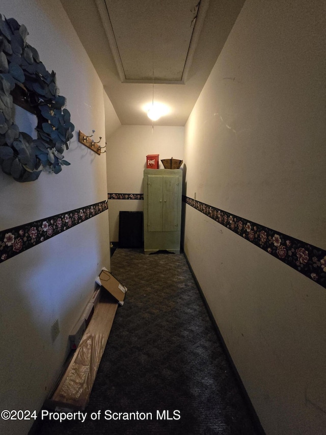 corridor featuring carpet flooring and a tray ceiling