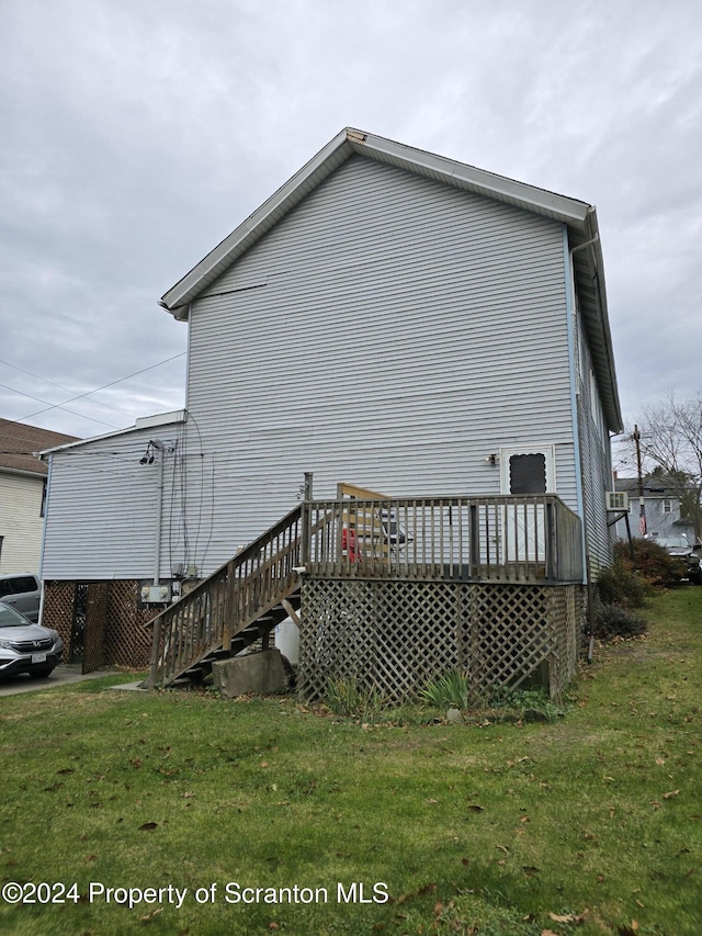 view of side of property with a deck and a yard