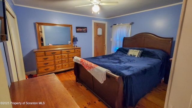 bedroom featuring wood finished floors, a ceiling fan, and crown molding