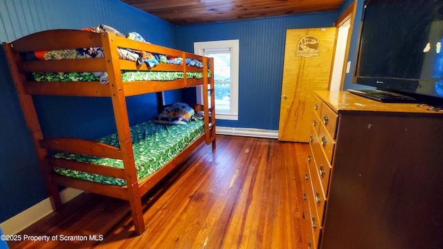 bedroom with baseboards, wood-type flooring, and wooden ceiling