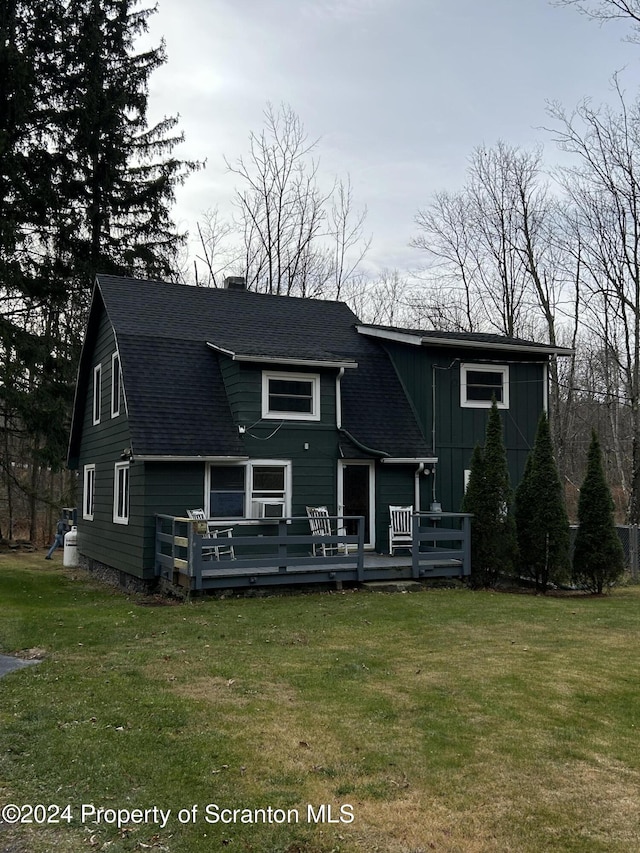 rear view of house with a deck and a lawn