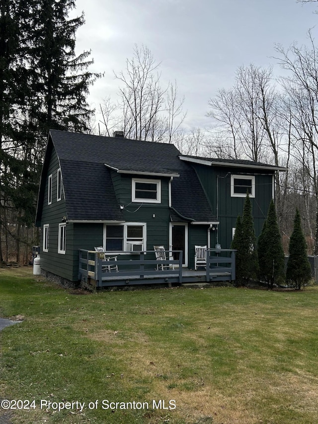 view of front of home featuring a front lawn and a wooden deck