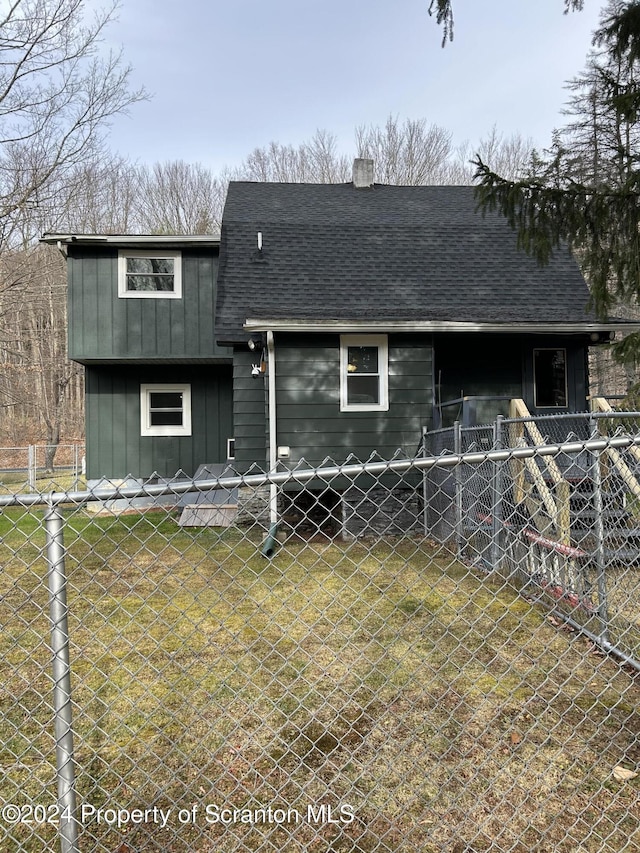 rear view of property featuring a lawn