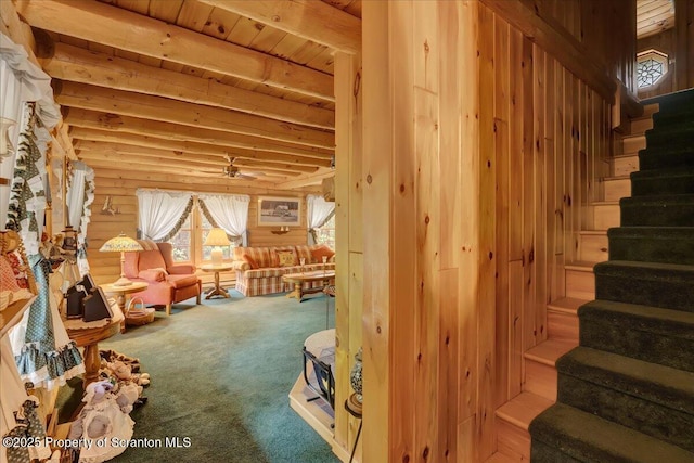 58 Sunset Dr, Clifton Twp, PA 18424 - interior space featuring stairs, carpet floors, beamed ceiling, a ceiling fan, and log walls