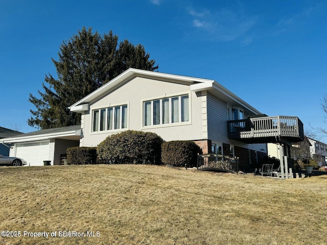 view of side of property with a garage, a yard, a deck, and stucco siding