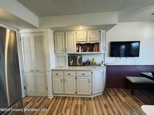 bar featuring wood finished floors and freestanding refrigerator