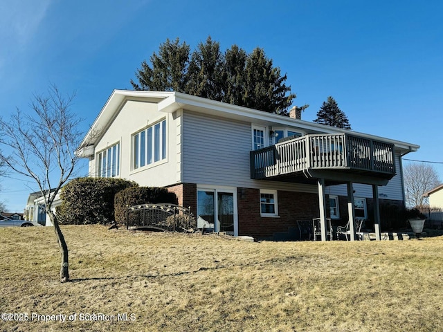 back of house with brick siding and a deck