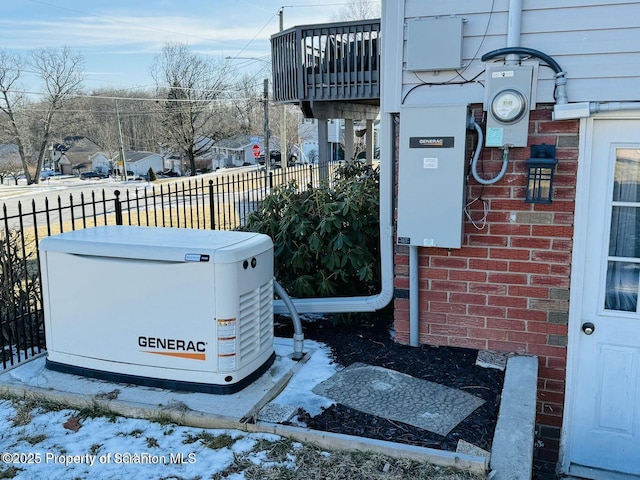 details with electric meter, fence, brick siding, and a power unit