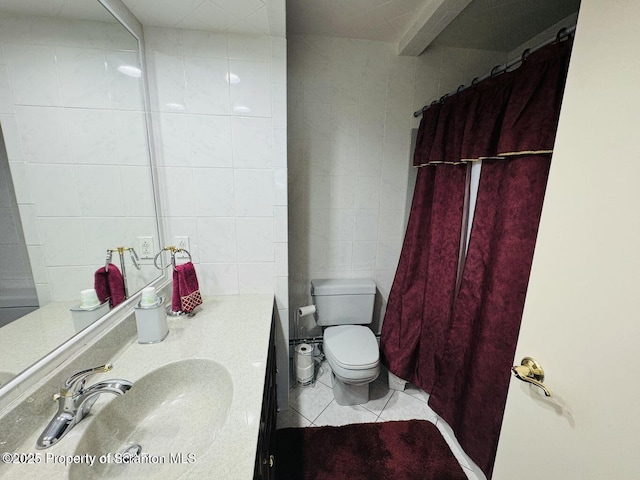 bathroom with a shower with shower curtain, toilet, tile patterned flooring, vanity, and tile walls