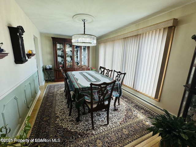 dining area featuring a notable chandelier and baseboard heating