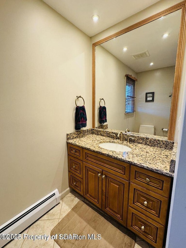 bathroom with a baseboard radiator, visible vents, toilet, vanity, and tile patterned floors