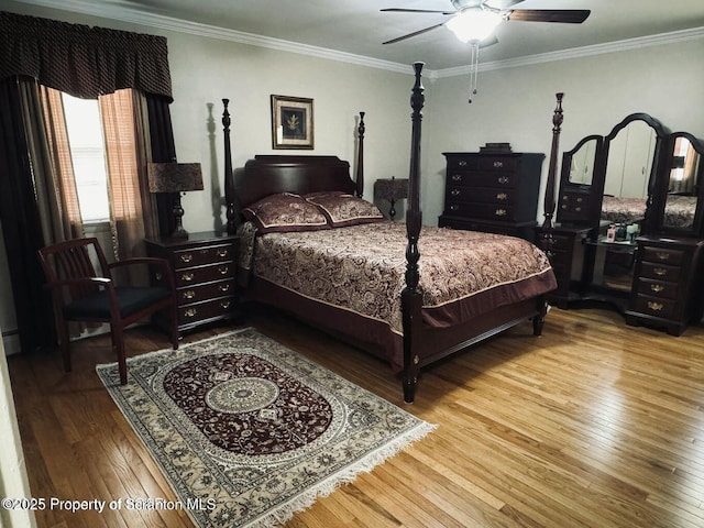 bedroom featuring ornamental molding, hardwood / wood-style flooring, and a ceiling fan