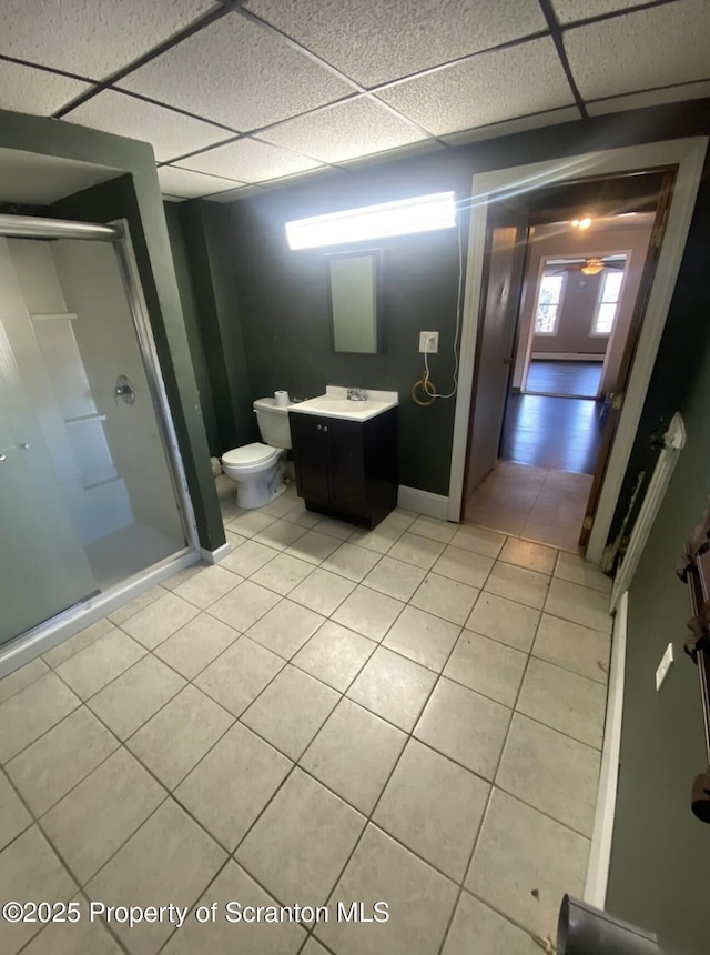 bathroom with tile patterned flooring, vanity, a drop ceiling, and walk in shower