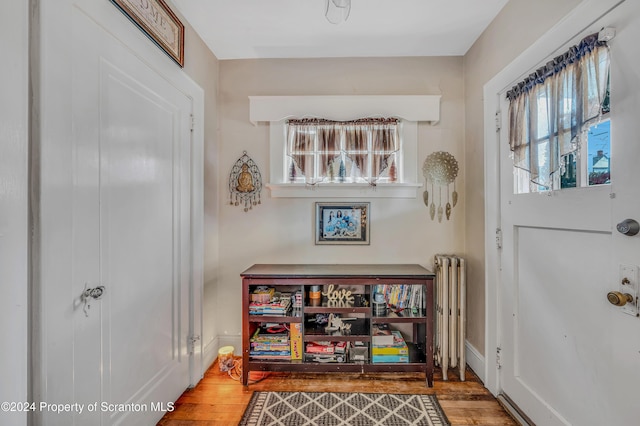 foyer with hardwood / wood-style flooring and radiator heating unit