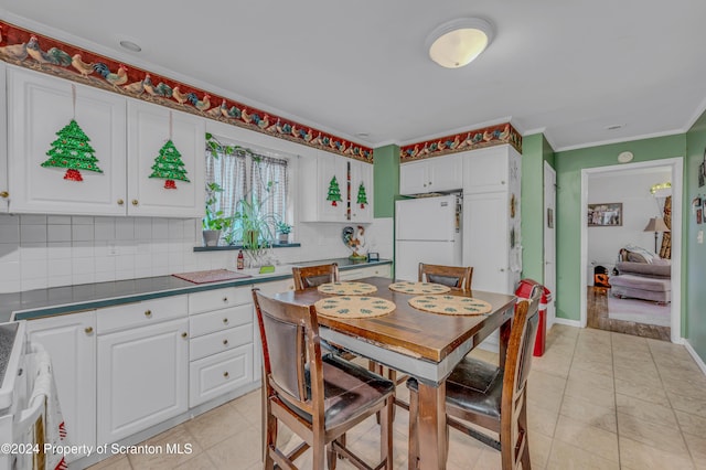 dining space with crown molding and light tile patterned floors