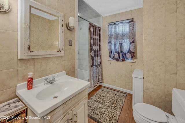 full bathroom featuring shower / tub combo, vanity, wood-type flooring, tile walls, and toilet