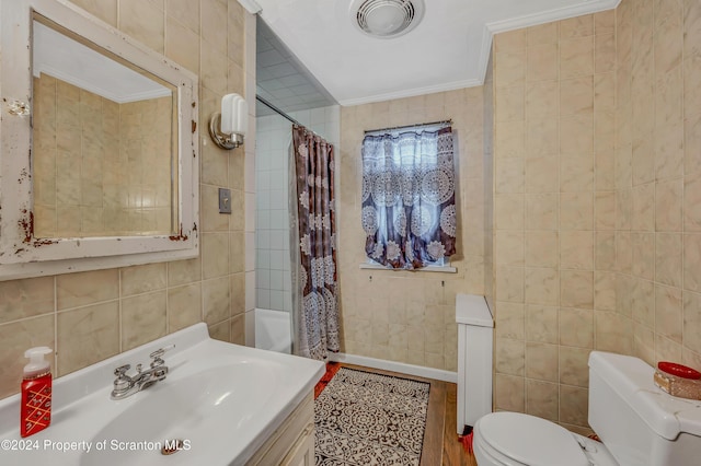 full bathroom with vanity, crown molding, toilet, shower / bath combo with shower curtain, and tile walls