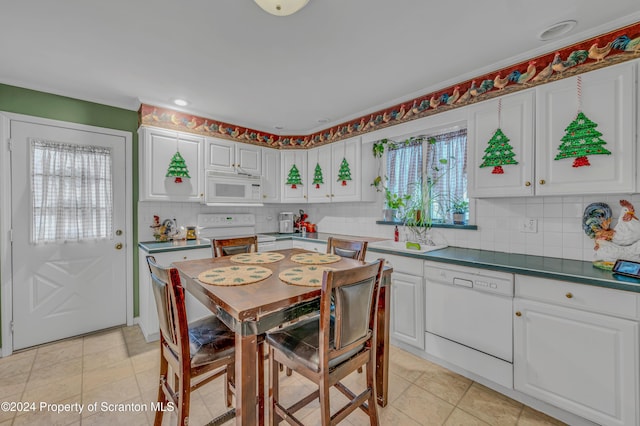 kitchen with white appliances, white cabinets, sink, light tile patterned floors, and tasteful backsplash