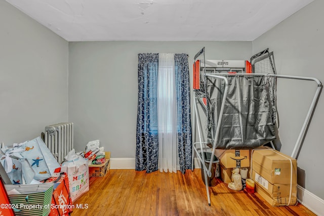 bedroom with hardwood / wood-style flooring and radiator heating unit