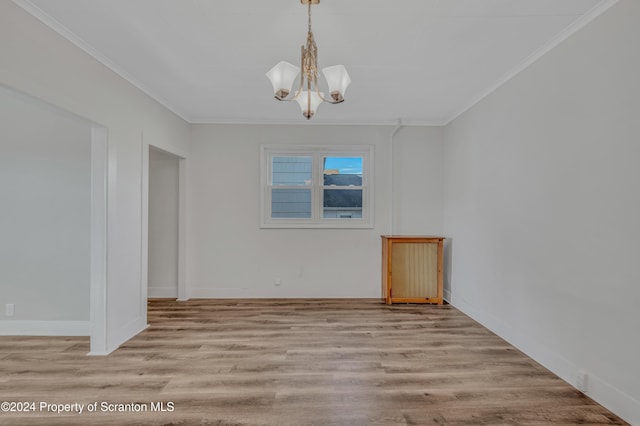 unfurnished dining area with a chandelier, light wood-type flooring, and crown molding