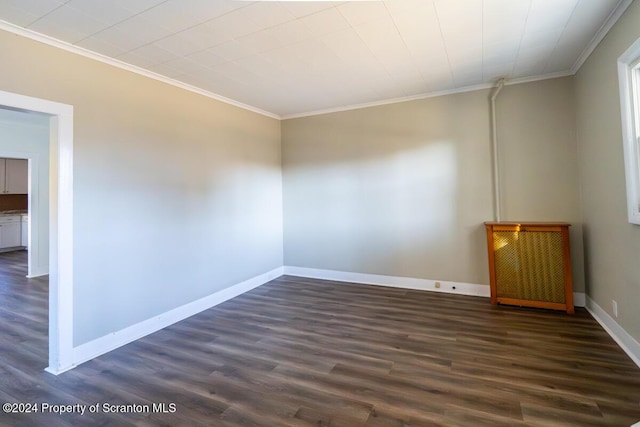 spare room featuring dark hardwood / wood-style flooring and crown molding